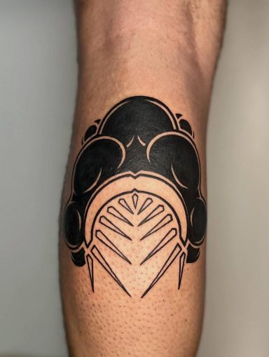 Schwarzes Tattoo auf dem Unterarm mit geschwungenen und spitzen Mustern.