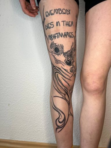Tattoo auf dem Oberschenkel mit Schriftzug und einem Octopus-Motiv.