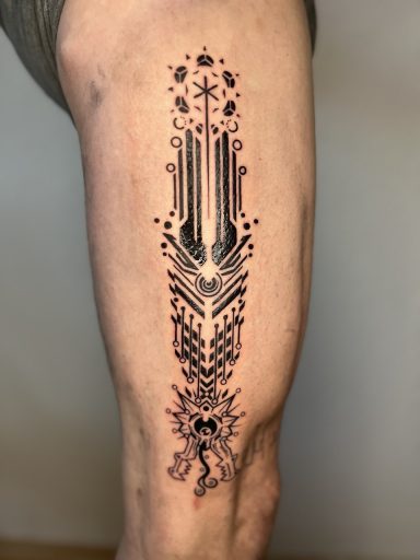 Schwarzes, geometrisches Tattoo mit floralen Mustern auf dem Oberschenkel.