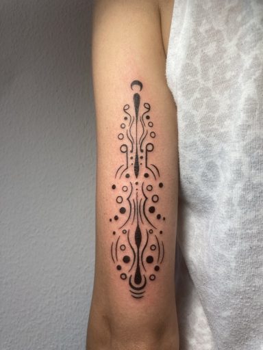 Schwarzes Tattoo mit geometrischem Design auf einem Unterarm.