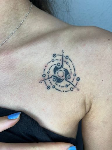 Tattoo auf der Schulter mit kreisförmigen Mustern und geometrischen Elementen.