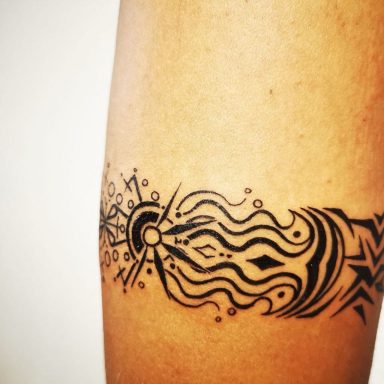 Schwarzes Tattoo mit einem abstrakten Muster von Linien und Punkten auf einem Oberschenkel.