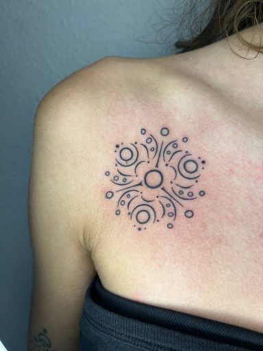 Schwarzes, florales Tattoo auf der oberen Schulter.