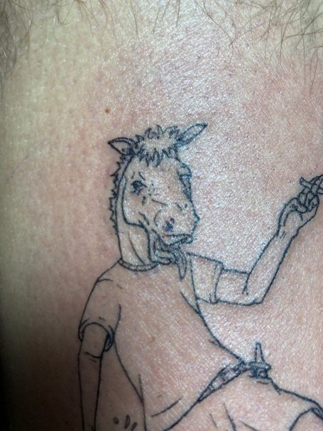 Tattoo eines menschenähnlichen Pferdes in T-Shirt, lässig mit einer Hand winkend.