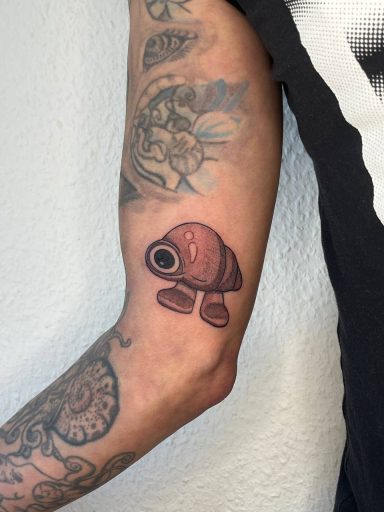 Tätowierung eines stilisierten Fisches auf einem Arm.