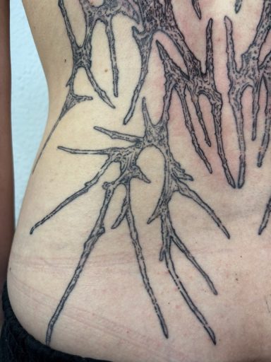 Tattoo mit einem modernen, geometrischen Design auf der linken Körperseite.