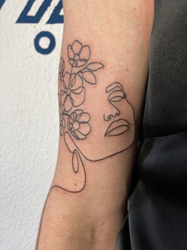 Linienzeichnung eines Gesichts mit Blumenmotiven auf einem Arm.
